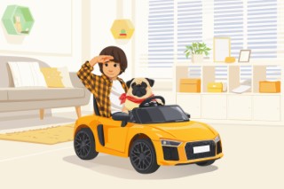 A boy playing with a small yellow toy car while his cat watches from a chair.