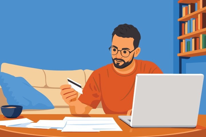 Man working at home office with laptop and credit card.