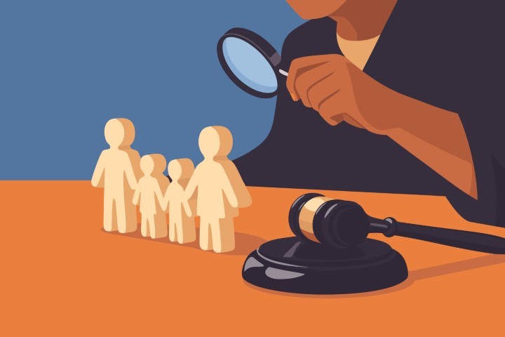 Legal gavel and small wooden figures being examined with a magnifying glass.