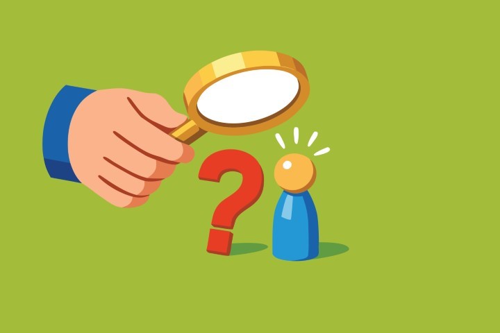 Hand holding a magnifying glass over a question mark and a human icon.