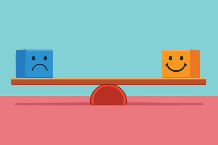 Weight scale balancing a sad blue face and a happy orange face.