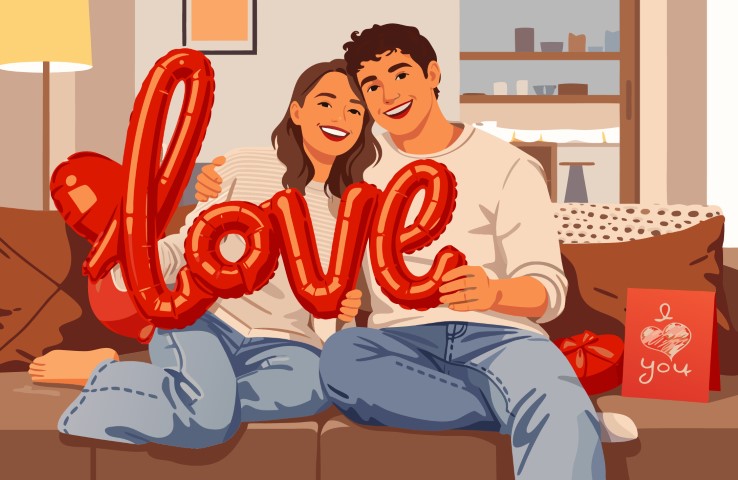 Couple relaxing together and holding large red love letter balloons.