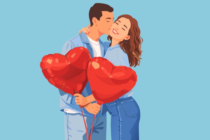 Young couple embracing while holding a bundle of red heart balloons.