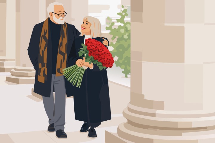 Elderly couple walking arm in arm near a classic architectural building.
