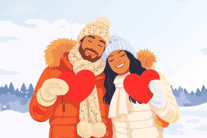 A happy couple dressed in cozy winter attire embraces warmly in a snowy landscape.