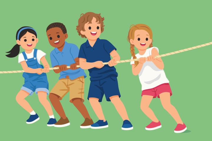 Group of diverse children playing tug of war on a green field.