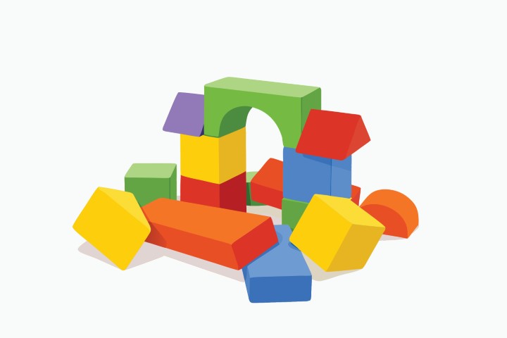 Colorful toy building blocks stacked in a pile on a white surface.