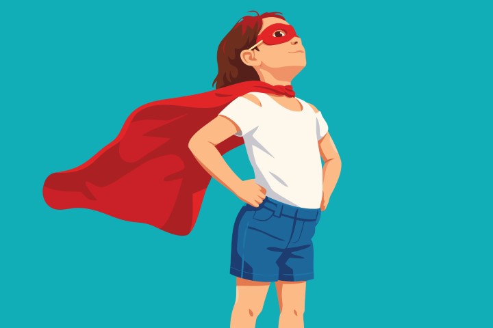 Child wearing a red superhero cape and posing confidently.
