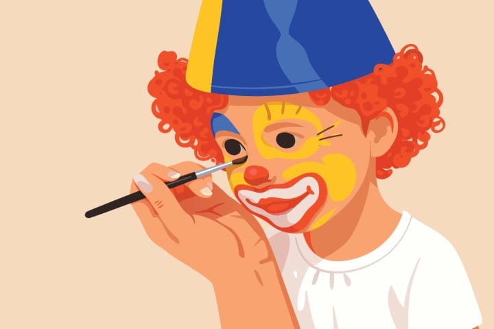 Professional entertainer applying colorful clown makeup on face using a small brush.