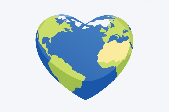 Hand holding a blue and green heart shaped earth representing global environmental care.