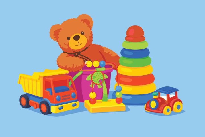 Colorful children toys like a teddy bear and stacking rings on a blue background.