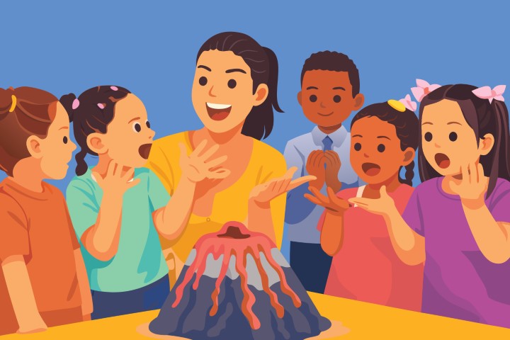 Group of happy children watching a volcanic eruption experiment.