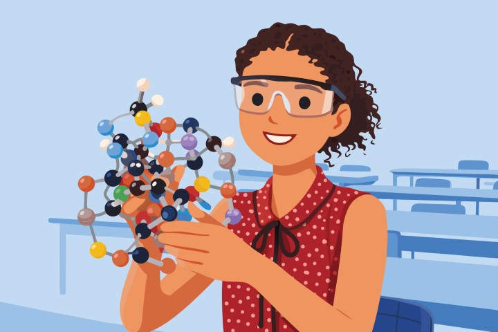 Student holding a colorful molecular structure model in a science classroom.