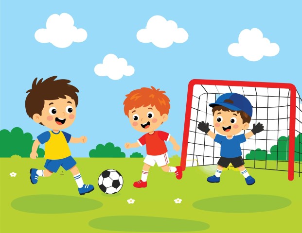 Happy children playing football on the green grass field near the goal net.
