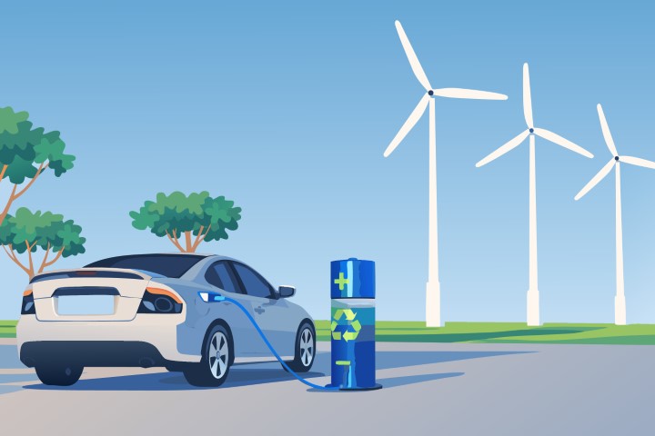Electric car driving past a wind farm on a coastal road.